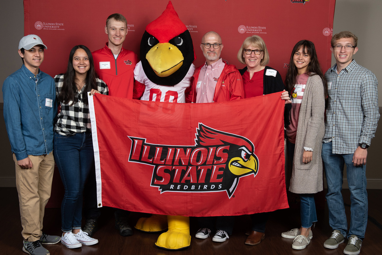 family and Reggie mascot hold ISU flag