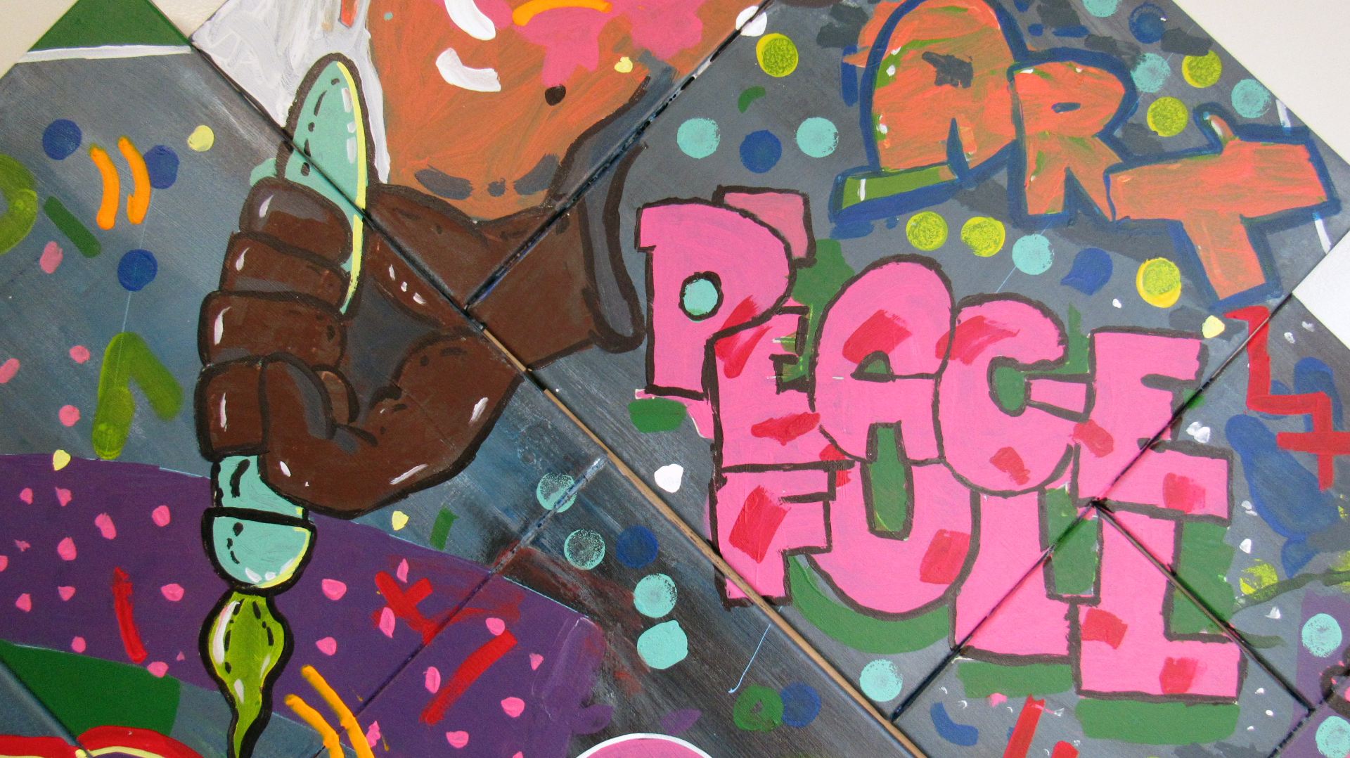 Graffiti art with hand holding paintbrush and the words, Art and Peace Full