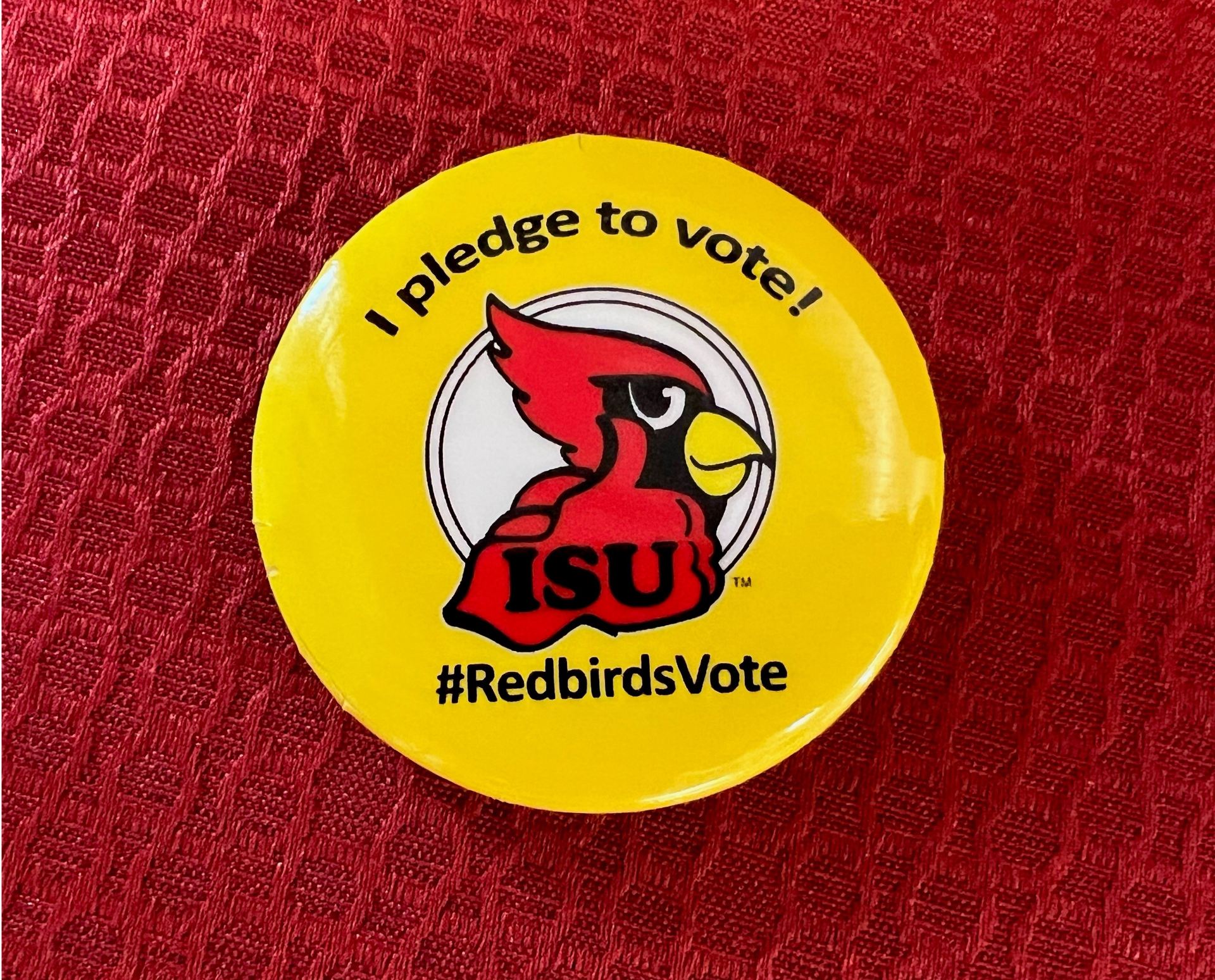 Yellow pin on red background, states I Pledge to Vote, #RedbirdsVote